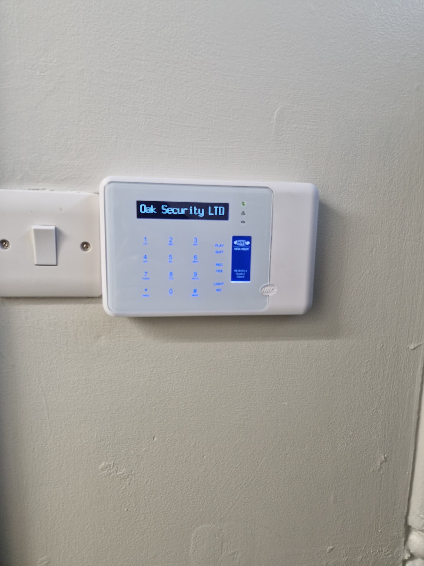 alarm keypad on a wall beside light switch