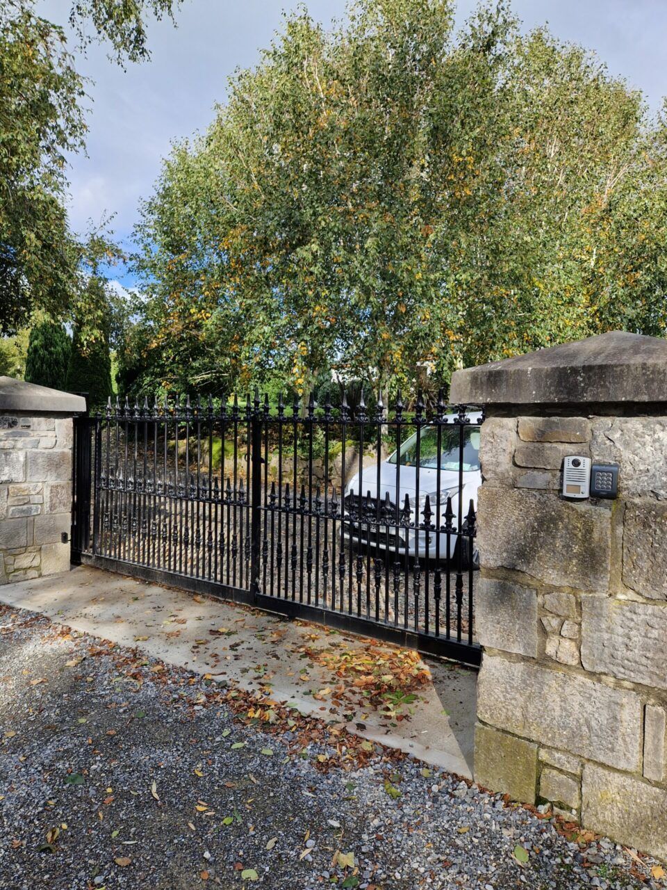 automated iron gates with stone pillars either side